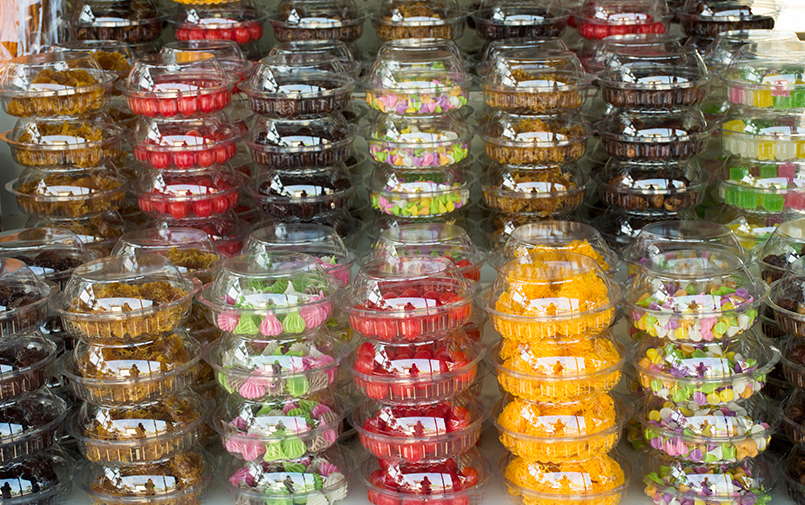 High clarity thermoformed PET plastic containers stacked on retail shelf displaying colorful confectionery