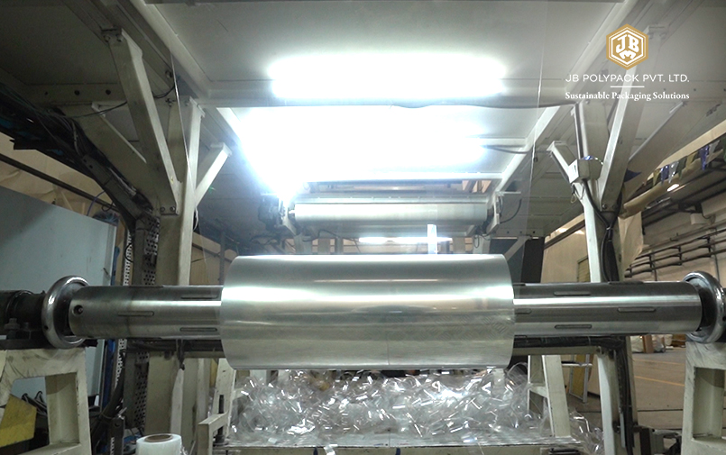 Transparent PET sheet being processed on industrial manufacturing machinery