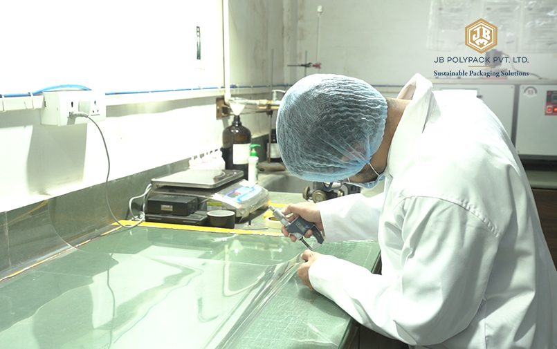 Quality control technician measuring transparent PET sheet thickness in a laboratory